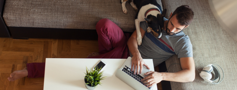 Man working from home on laptop with dog